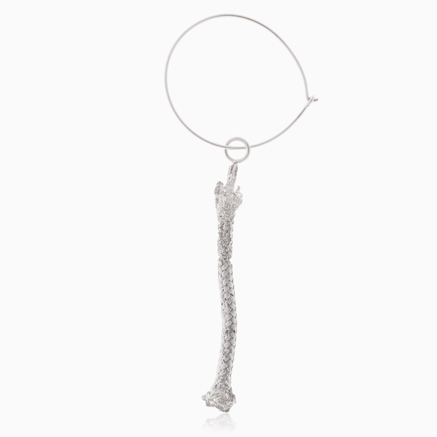 A sterling silver nautical hoop earring featuring a long, textured bone-shaped pendant hanging from it, artisan-made for a unique touch.