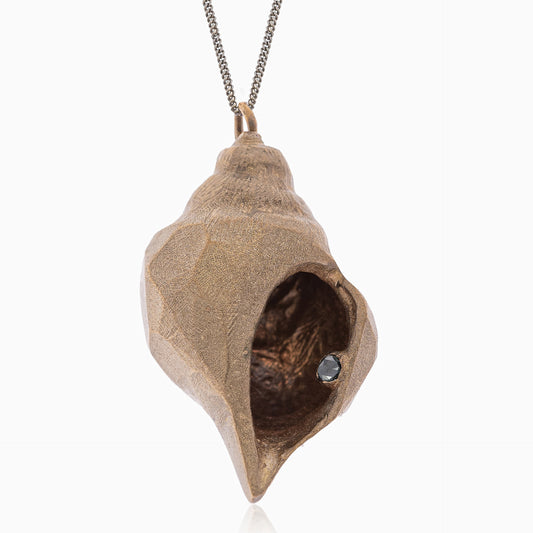 Handmade by Angela Lago, the Nautical Handcrafted Seashell One of A Kind Pendant Nº 1 is a unique bronze conch shell pendant that features a small black diamond inside, elegantly hung on a chain against a white background.