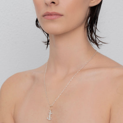 A person with short, dark hair wears the handcrafted sterling silver "Underwater Anchor" pendant by Angela Lago, against a plain gray background.