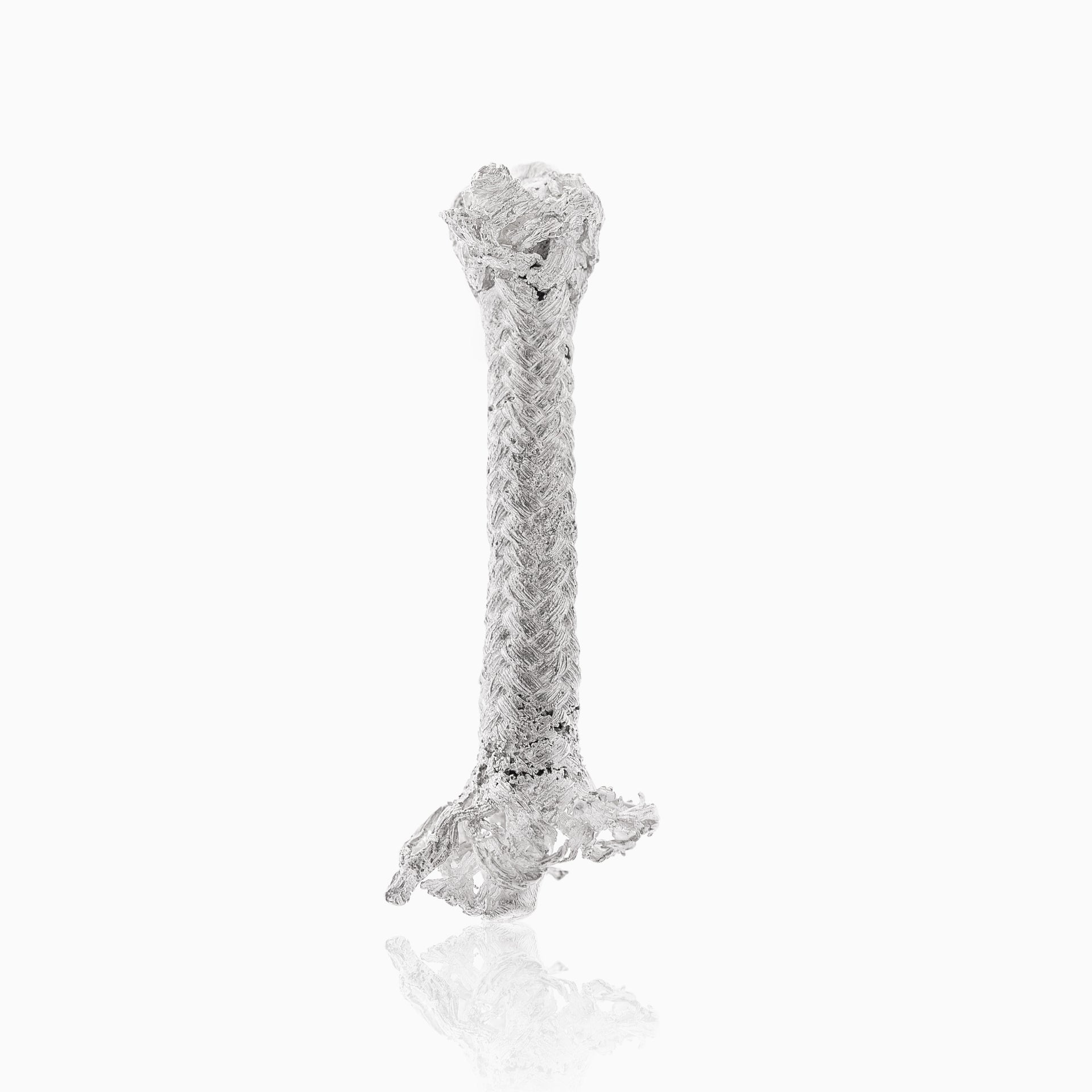 A frayed piece of the Earring Sterling silver rope M, cylindrical in shape and reminiscent of Angela Lago's handmade jewelry, is vertically positioned on a white background.