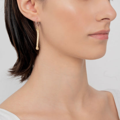 Close-up of a person with short dark hair wearing a Thin Hoop Nautical Earring featuring a 24k gold-plated rope design on the left ear.