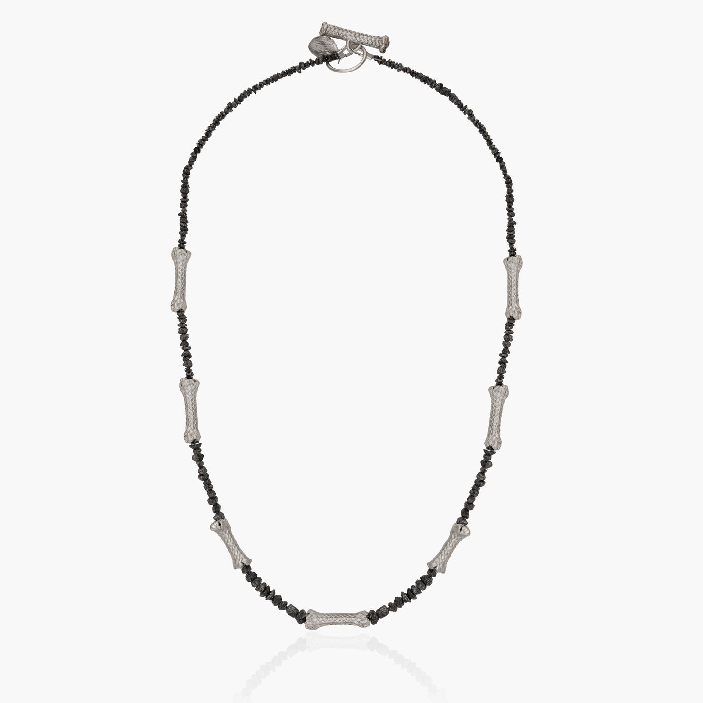 A one-of-a-kind necklace named "Raw Black Diamonds and Sterling Silver Ropes," featuring a beaded chain with evenly spaced metal bar accents and adorned with raw black diamonds.