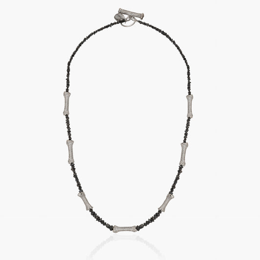 A one-of-a-kind necklace named "Raw Black Diamonds and Sterling Silver Ropes," featuring a beaded chain with evenly spaced metal bar accents and adorned with raw black diamonds.